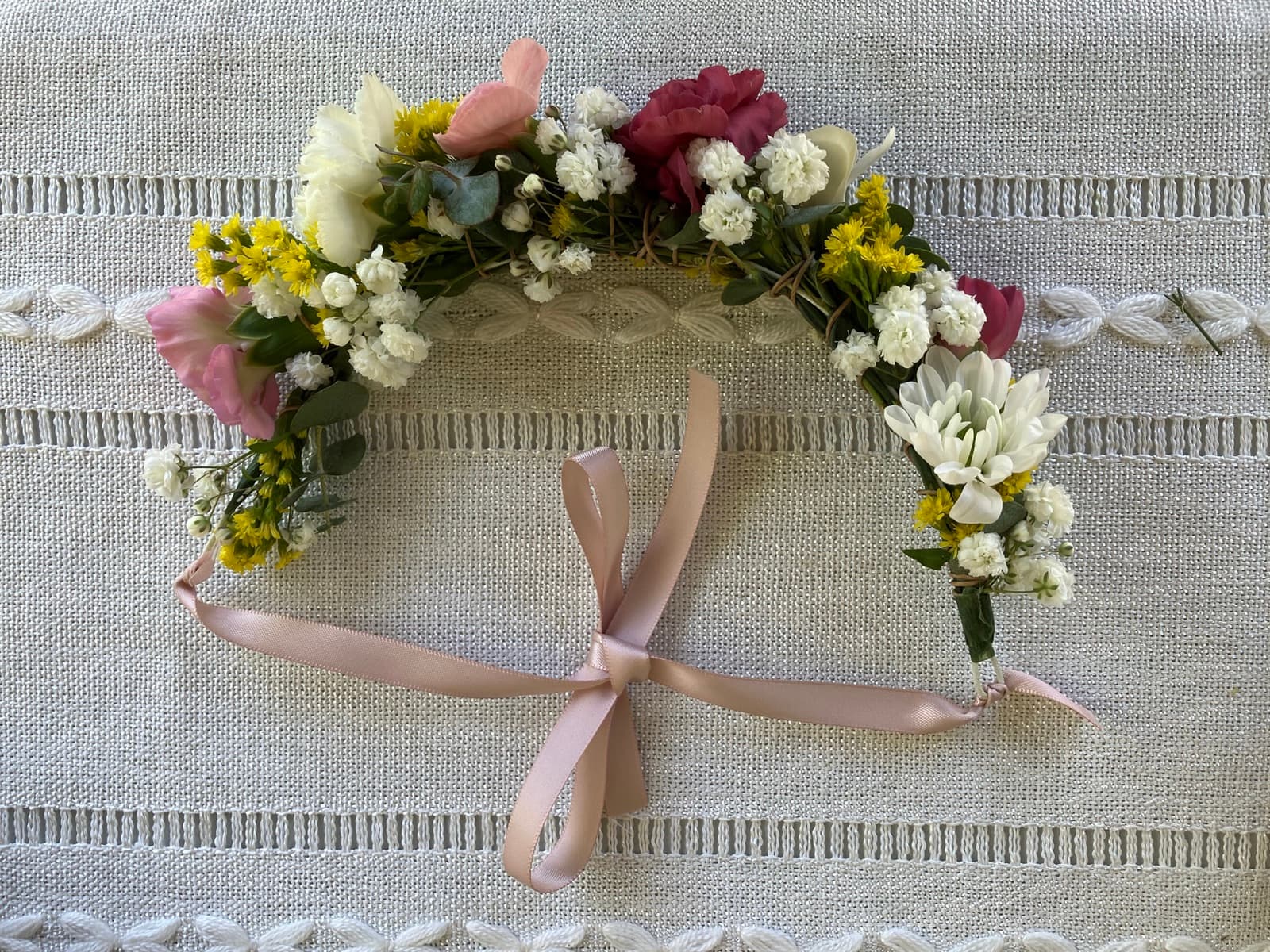Hand-crafted flower crown with seasonal blooms and a soft pink ribbon bow