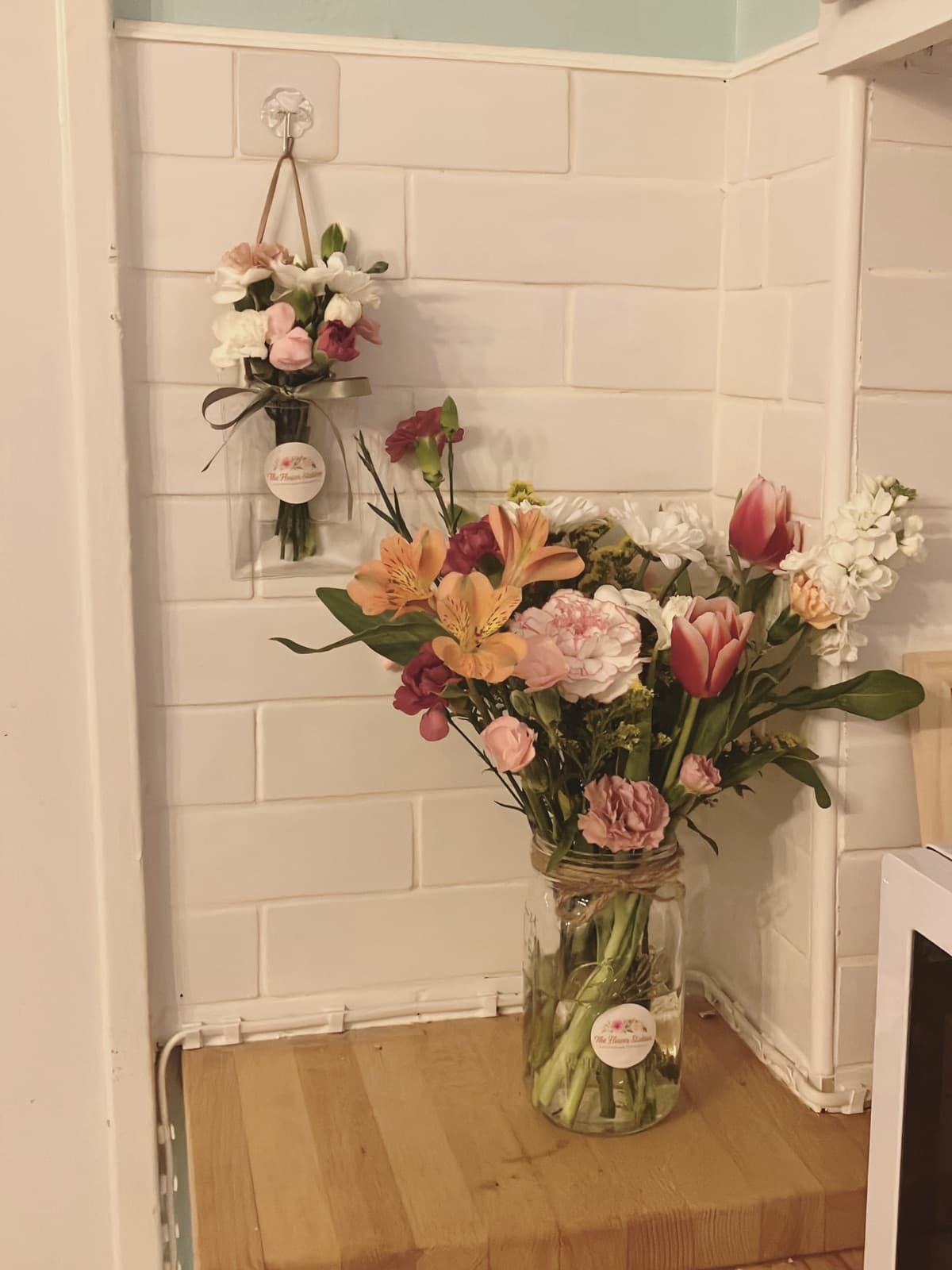 Branded flower arrangements in mason jars with The Flower Station logo