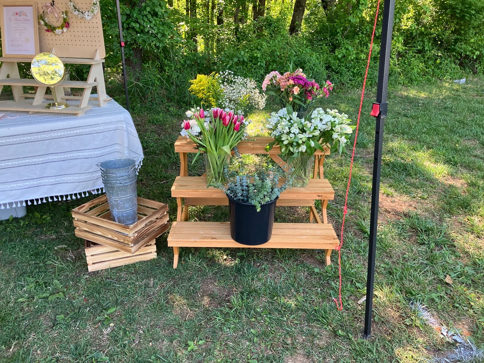 Wooden tiered display shelves with fresh tulips and seasonal blooms